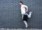 Fashion guy jumping against black brick wall with purchases, shopping