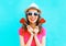 Fashion happy smiling woman with two red lollipop shape of a heart over colorful