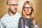 Fashion hipster couple in love in glasses posing on a gold backg