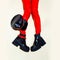 Fashion legs in platform party boots and red leather leggins and cap on minimal background. Stylish clubbing 90s fashion