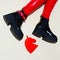 Fashion legs in platform party boots and red leather leggins on minimal background. Stylish clubbing 90s fashion