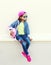 Fashion little girl child wearing a sunglasses, baseball cap and backpack in city over white