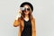 Fashion look, pretty cool young woman model with retro film camera wearing a elegant hat, brown jacket, curly hair outdoors