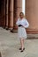 Fashion look`s woman. Young woman modern portrait. Young woman dressed in white skirt and shirt posing near the old building.