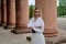 Fashion look`s woman. Young woman modern portrait. Young woman dressed in white skirt and shirt posing near the old building.