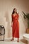 Fashion model brunette hair wear red silk dress sandals high heels accessory clothes for date party walk interior furniture