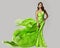 Fashion Model dancing in Green Silk Dress with Flying Chiffon Fabric. Beauty Woman in Long Satin Evening Gown over White. Elegant