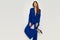 Fashion model in elegant navy blue suit is posing on one leg