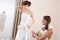 Fashion model fitting wedding dress by designer