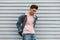 Fashion model good-looking young man in stylish pink sweatshirt in fashionable blue denim jacket with fabric shopper near vintage