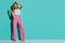 Fashion Model In Red Striped Wide Leg Trousers Standing Aginst Turquoise Wall