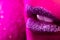 Fashion model with shiny sparkles on plump lips. Pink neon studio light. Macro view of woman with glamorous make-up