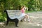 Fashion model sits on a park bench