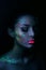 Fashion model woman in neon light bright fluorescent makeup, drop on face. Beautiful model brunette girl colorful make-up, painted