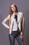 Fashion model woman in white leather coat and jeans