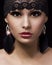 Fashion muslim portrait. Beautiful gypsy young woman with professional makeup and lace accessories over black