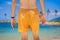 Fashion outdoor image of stylish man walking alone at beautiful beach, enjoy freedom and nice relaxed vacation day