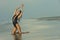 Fashion outdoor photo of gorgeous brunette woman in elegant black swimsuit posing on the beach.