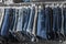 Fashion pants and jeans on the rack in clothing store. Sale, shopping, fashion, style concept. Jean Pants Hang on Shelf