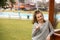 Fashion picture of a young beautiful woman leaned against wooden gazebo