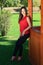 Fashion picture of a young beautiful woman leaned and posing against wooden gazebo