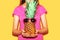 Fashion pineapple with pink sunglasses on hands woman over yellow