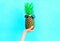 Fashion pineapple with sunglasses on blue background, hand ananas