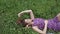 Fashion portrait of beautiful female brunette girl model lying on grass in the park