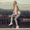 Fashion portrait of blonde woman. Jeans and sneakers.