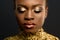 Fashion Portrait of Glossy African American Woman with Bright Golden Makeup. Bronze Bodypaint, Black Studio Background