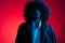 Fashion portrait of a man with curly hair on a red background, multinational, colored light, trendy, modern concept.