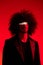 Fashion portrait of a man with curly hair on a red background, multinational, colored light, trendy, modern concept.