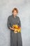Fashion portrait of perfect mature woman with short ginger hair holding fall maple leaves, studio portrait