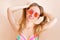 Fashion portrait pretty woman in summer red sunglasses over colorful peach background