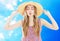 Fashion portrait pretty woman in summer straw hat sends an air kiss over fresh blue background