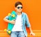 Fashion portrait teenager boy with skateboard wearing a sunglasses