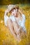 Fashion portrait woman with hat and white shirt sitting on a hay stack