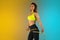 Fashion portrait of young fit and sportive woman with measurer on gradient background. Perfect body ready for summertime