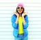 Fashion pretty cool shocked woman in colorful clothes having fun over white background wearing a pink hat yellow sunglasses