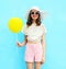 Fashion pretty woman in straw hat with air balloon over colorful blue