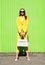 Fashion pretty woman in yellow suit clothes with handbag posing