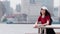 Fashion pretty young girl with black long hair, wearing red T-shirt and white baseball cap posing outdoor, minimalist urban clothi