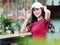 Fashion pretty young girl with black long hair, wearing red T-shirt and white baseball cap posing outdoor, minimalist urban clothi