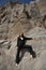 Fashion sexy woman in a suit posing on sand rocks. Modern independent girl, beautiful makeup