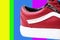 Fashion shoes with shoestring. Red sneaker and shoelace on a colorful background