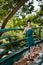 Fashion slim woman wearing green dress standing against bridge