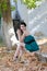 Fashion slim woman wearing green strapless short dress sitting sidewalk