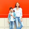 Fashion smiling mother with son teenager together on red
