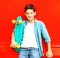 Fashion smiling teenager boy with skateboard in a checkered shirt