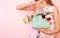 Fashion spring accessories - girl holding mint handbag purse and sunglasses on pastel pink